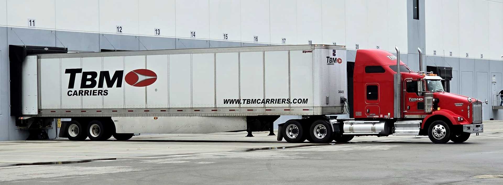 A TBM Carriers tractor-trailer backed into a numbered loading dock